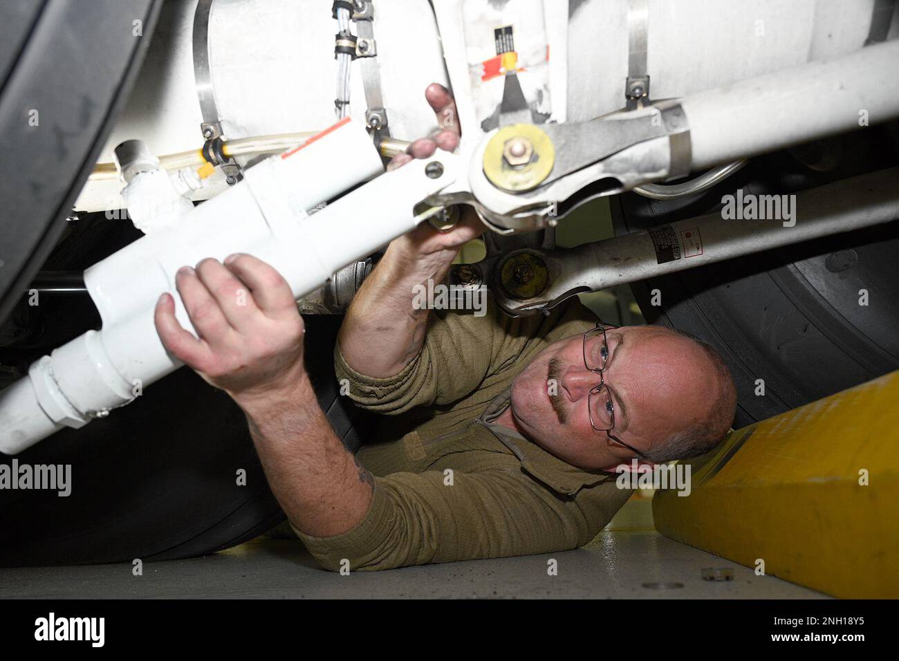 David Thomas, capo equipaggio dello Squadrone di manutenzione 191st, Selfridge Air National Guard base, Michigan, installa un nuovo cilindro di centraggio del carrello di atterraggio su uno Stratotanker KC-135 il 6 dicembre 2022. Un team dello Squadron Air Mobility Command Test and Evaluation, McGuire-Dix-Lakehurst, New Jersey, ha scelto Selfridge per testare e osservare il personale addetto alla manutenzione installare i nuovi cilindri e testare il carrello di atterraggio mentre l'aeromobile poggia sui martinetti. Foto Stock