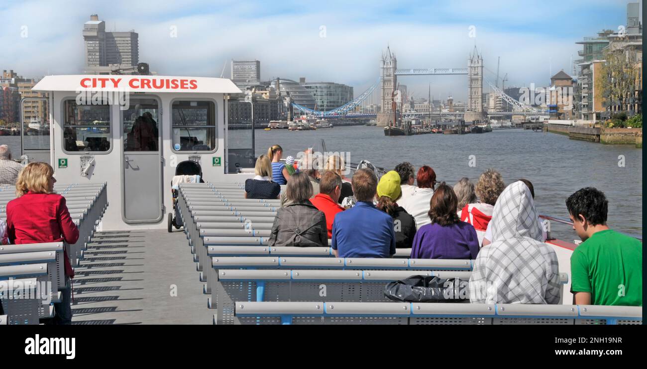 River Thames City Cruises giro turistico di monumenti storici vista posteriore dei turisti seduti in barca che si avvicinano al Tower Bridge nella piscina di Londra UK Foto Stock