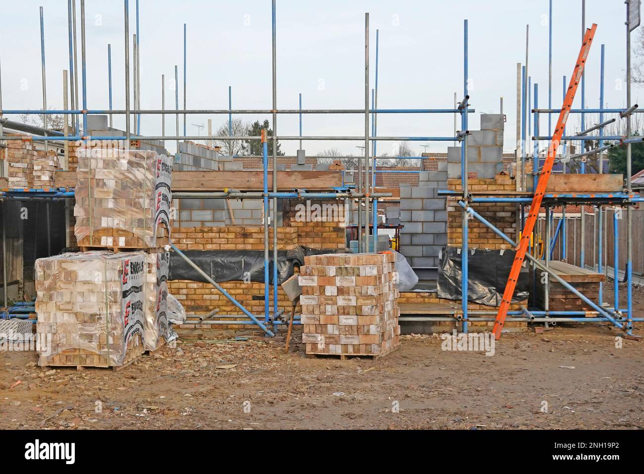 Materiali da costruzione impilati su scala di accesso del cantiere di costruzione della casa in posizione staccata pareti della cavità della casa di mattoni di fronte & blocchi isolanti UK Foto Stock