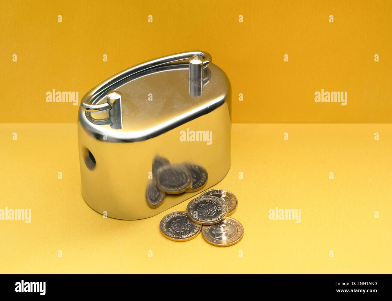 Monete metalliche e lire turche su sfondo giallo. Foto Stock