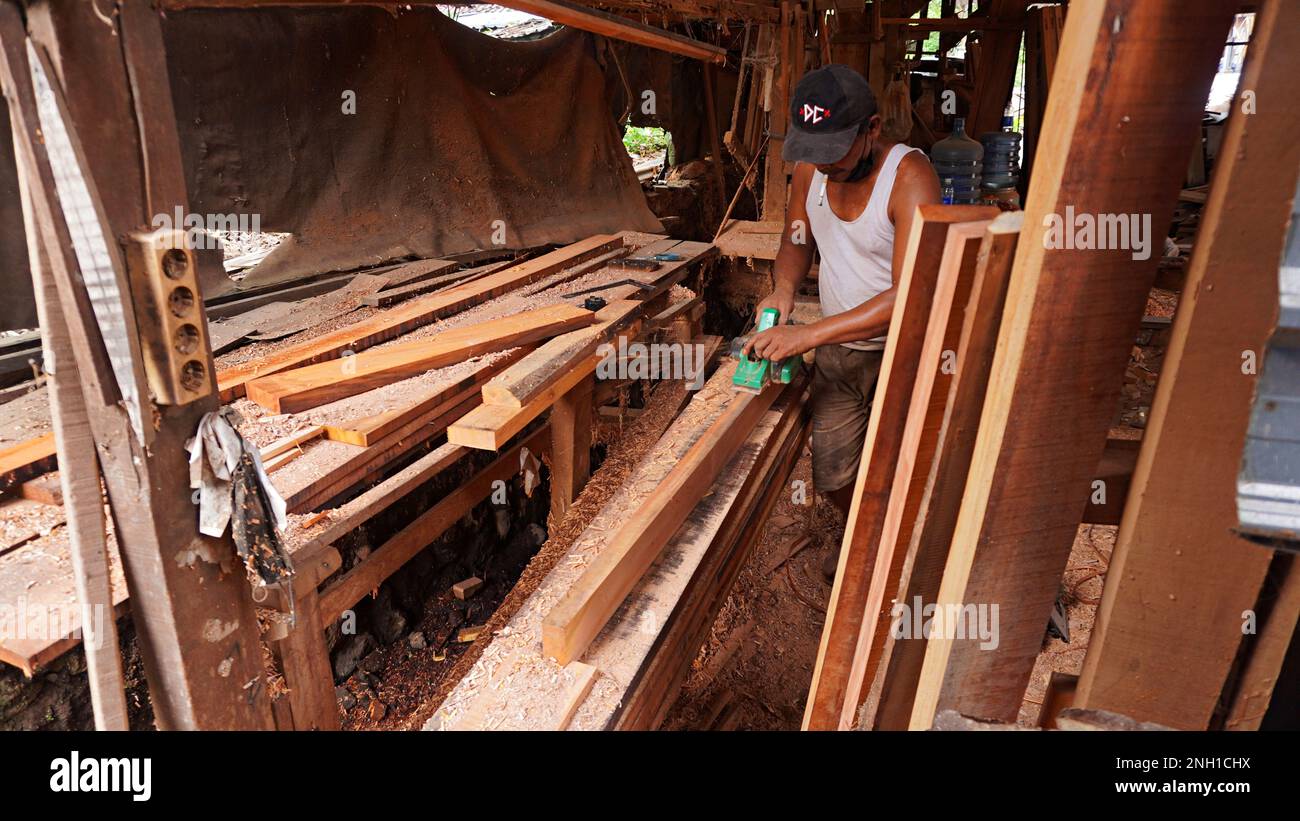 i carpentieri della mobilia stanno lisciando i blocchi di legno usando una macchina per fare le necessità interne per le case e gli uffici quali gli armadietti di riempimento, i tavoli, la sedia Foto Stock i carpentieri della mobilia stanno lisciando i blocchi di legno usando una macchina per fare le necessità interne per le case e gli uffici quali gli armadietti di riempimento, i tavoli, la sedia Foto Stock