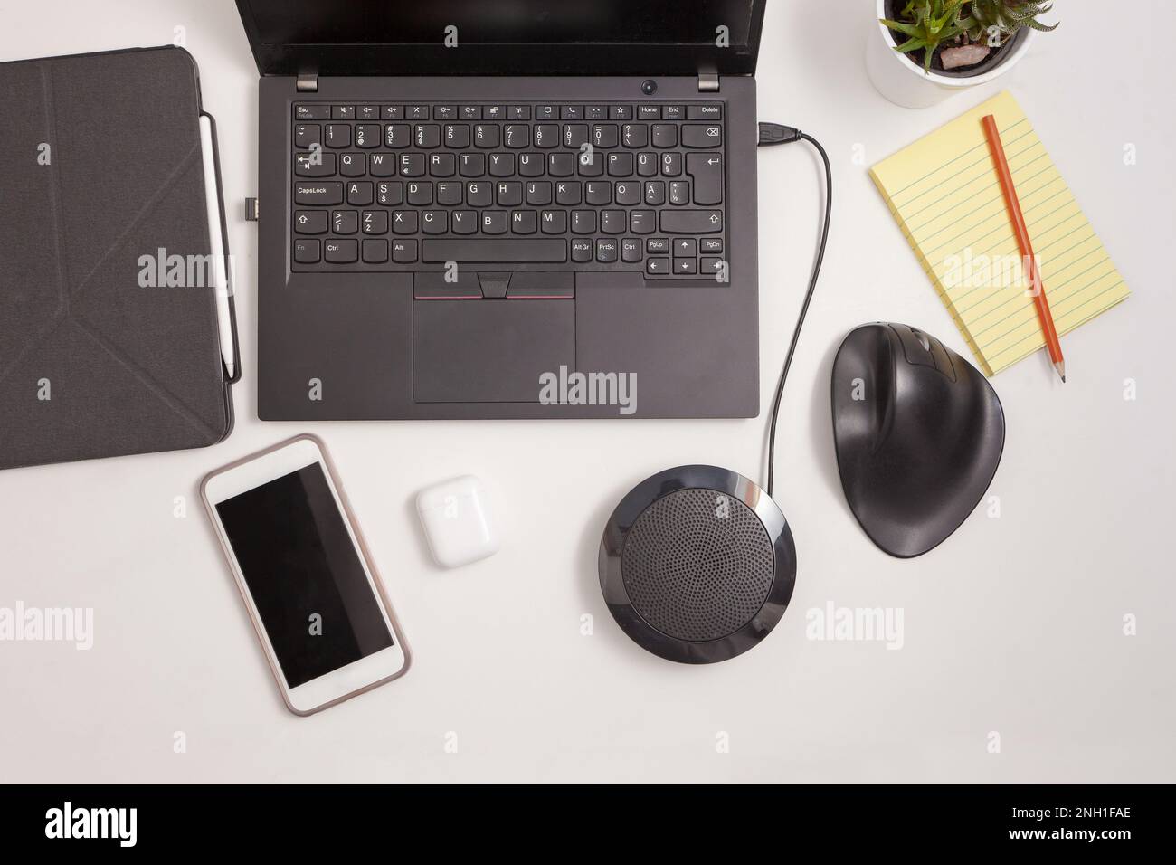 postazione di lavoro con mouse ergonomico, telefono cellulare, cuffie, colonna e notebook tablet Foto Stock