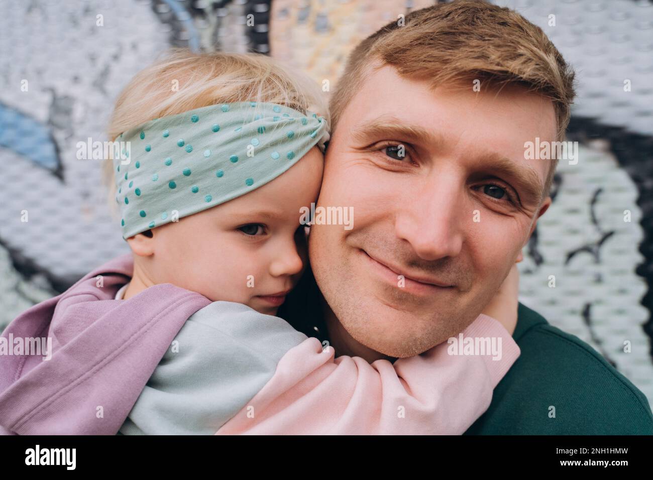Primo piano ritratto di padre e figlia in felpe con cappuccio, colori pastello Foto Stock
