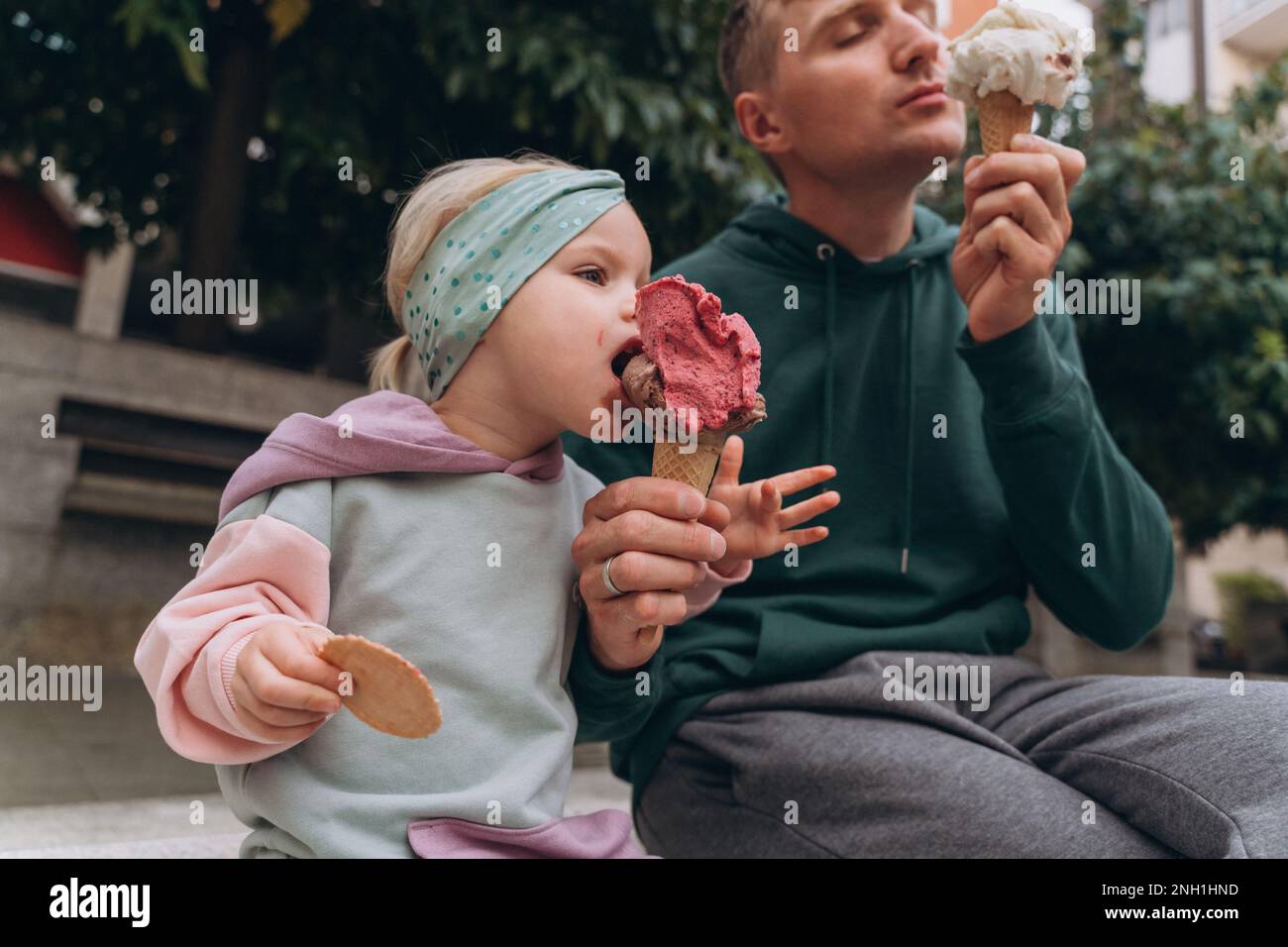 Uomo e bambino che mangiano gelato italiano per strada Foto Stock