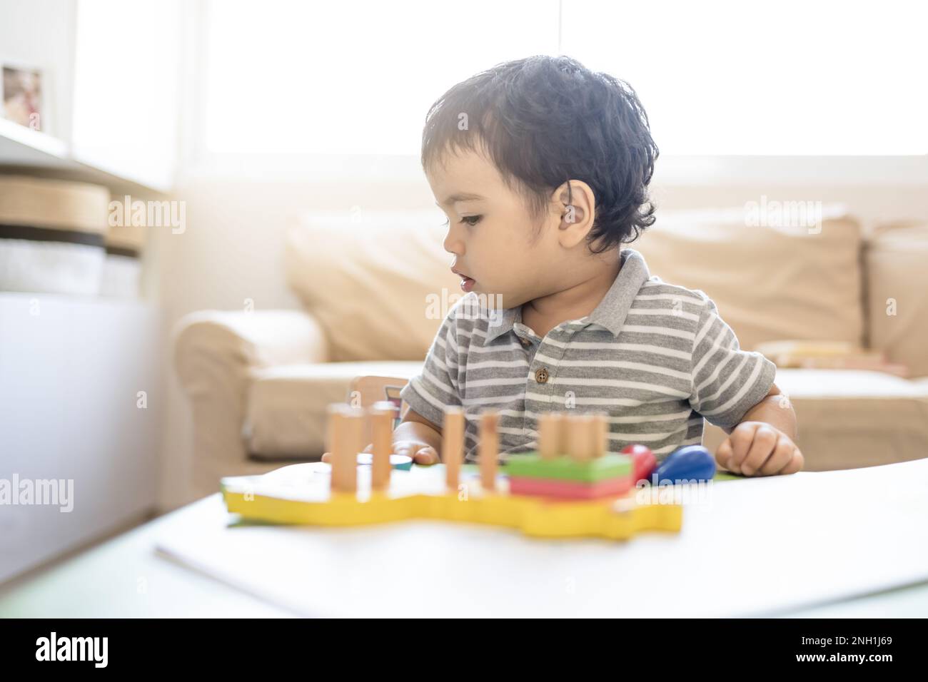 Bambino con giocattoli di logica educativa nel soggiorno Foto Stock