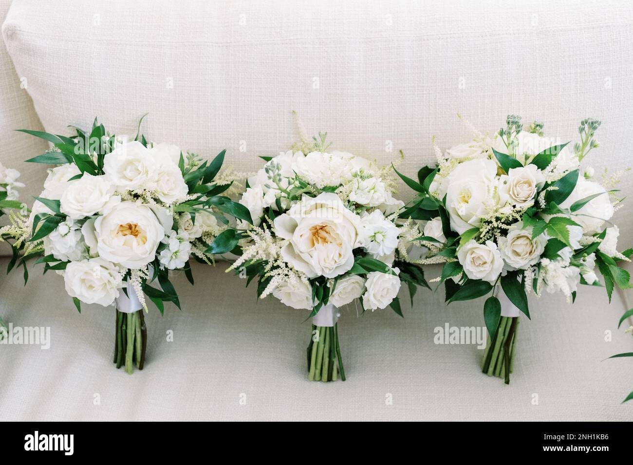 tre bouquet di nozze con tutti i fiori bianchi e verde su biancheria Foto Stock