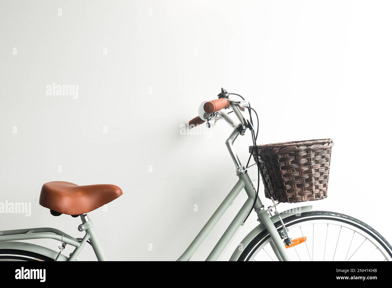 bicicletta verde vintage con cesto marrone su sfondo bianco Foto Stock