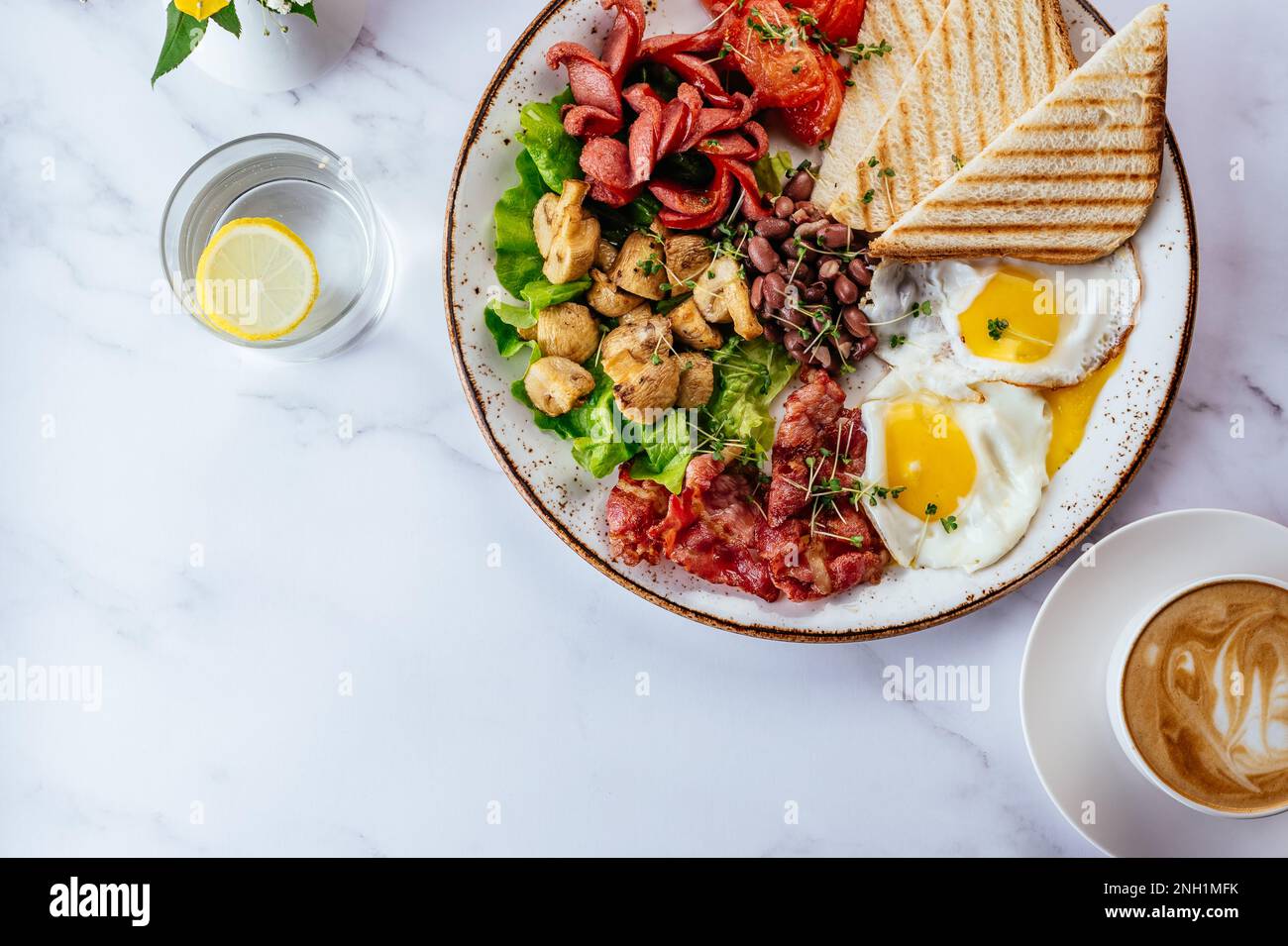 colazione all'inglese con uova strapazzate, pancetta, fagioli, funghi a. Foto Stock