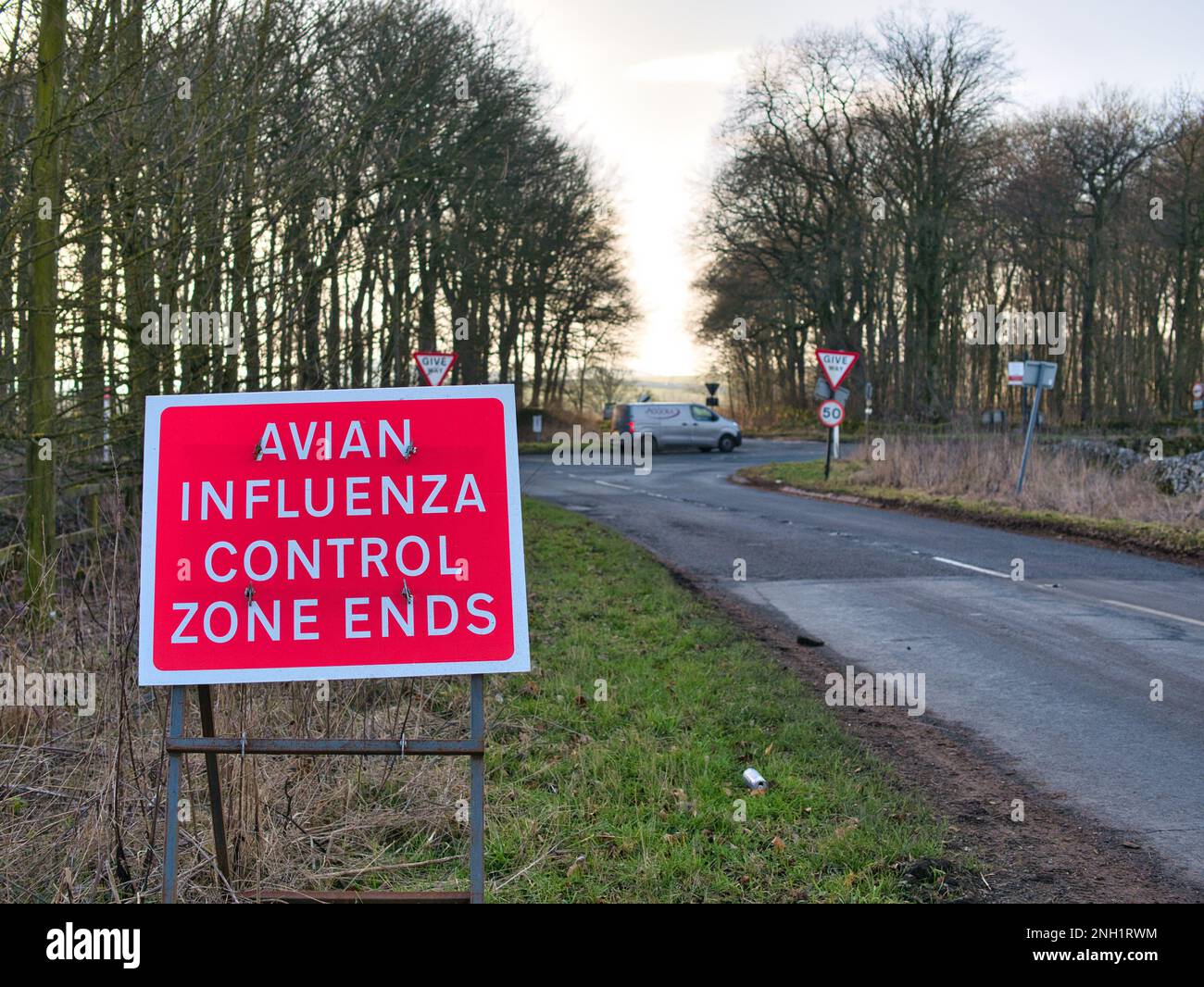 Un segnale di avvertimento rosso sul lato di una strada avverte che il lettore sta uscendo da una zona di controllo dell'influenza aviaria. Sotto il sole d'inverno con un cielo blu a Derby Foto Stock Un segnale di avvertimento rosso sul lato di una strada avverte che il lettore sta uscendo da una zona di controllo dell'influenza aviaria. Sotto il sole d'inverno con un cielo blu a Derby Foto Stock