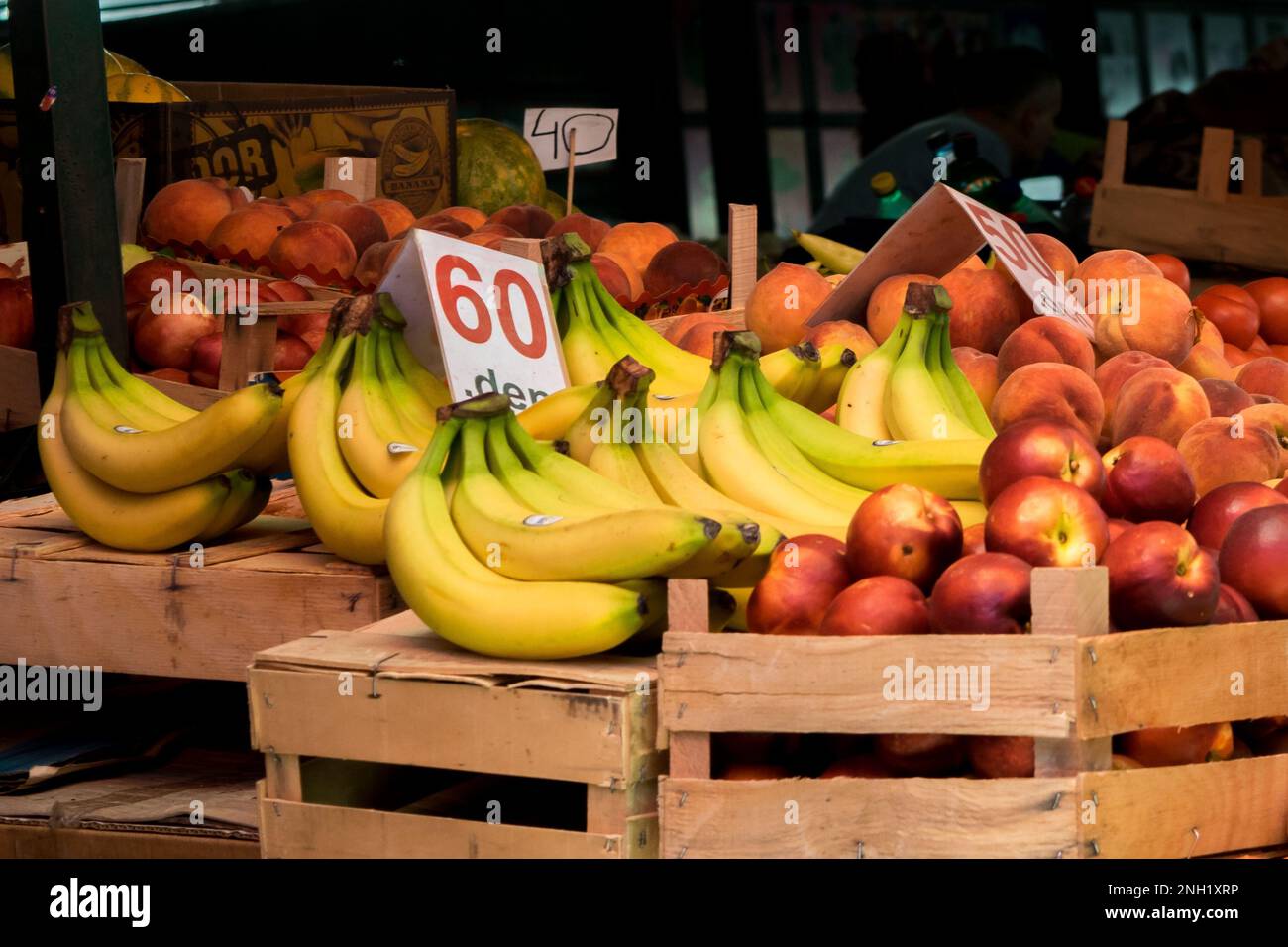 Uno stallo in un mercato verde aperto a Tetovo, Macedonia settentrionale, con il venditore che vende frutta e verdura fresca. Prodotti immagazzinati in scatole di legno. Foto Stock