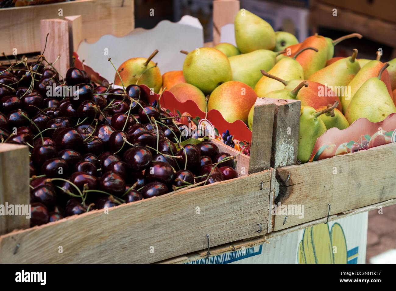 Uno stallo in un mercato verde aperto a Tetovo, Macedonia settentrionale, con il venditore che vende frutta e verdura fresca. Prodotti immagazzinati in scatole di legno. Foto Stock