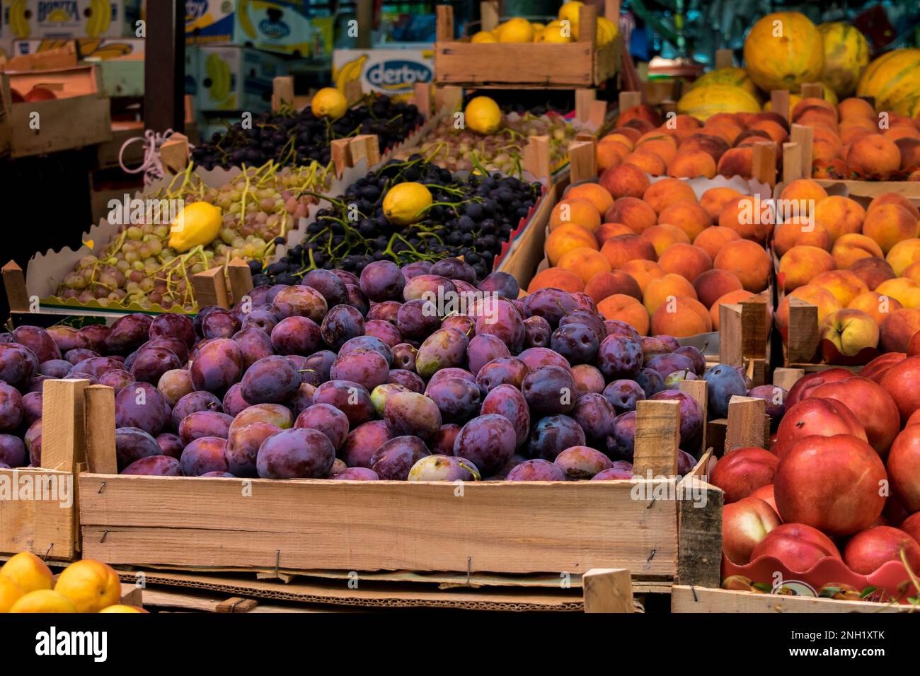 Uno stallo in un mercato verde aperto a Tetovo, Macedonia settentrionale, con il venditore che vende frutta e verdura fresca. Prodotti immagazzinati in scatole di legno. Foto Stock