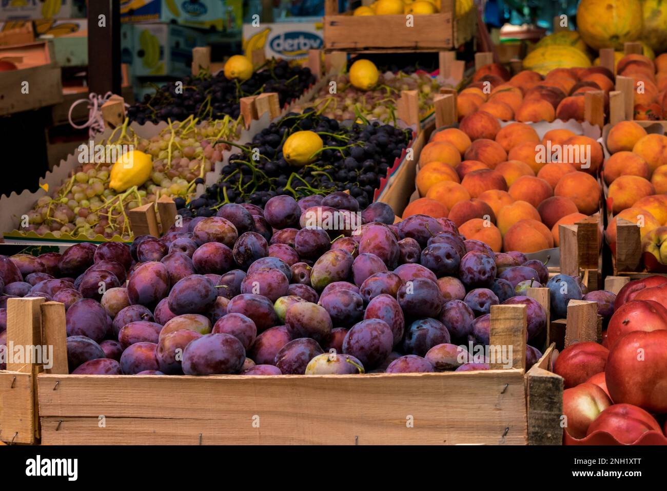 Uno stallo in un mercato verde aperto a Tetovo, Macedonia settentrionale, con il venditore che vende frutta e verdura fresca. Prodotti immagazzinati in scatole di legno. Foto Stock