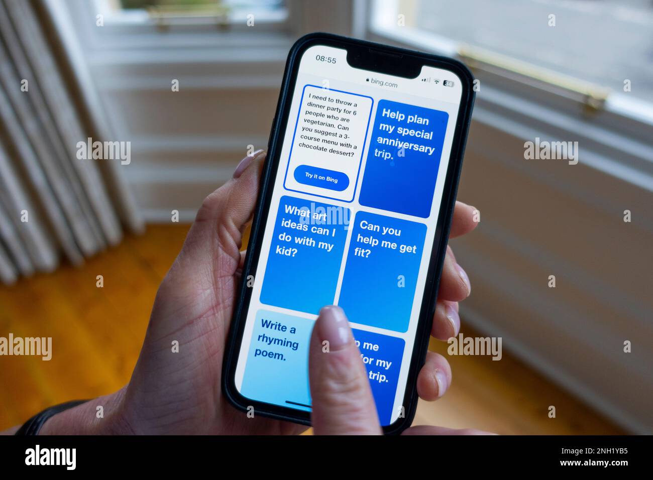 La persona tiene il telefono cellulare che mostra le nuove opzioni del motore di ricerca Microsoft ChatGPT OpenAI Bing Foto Stock