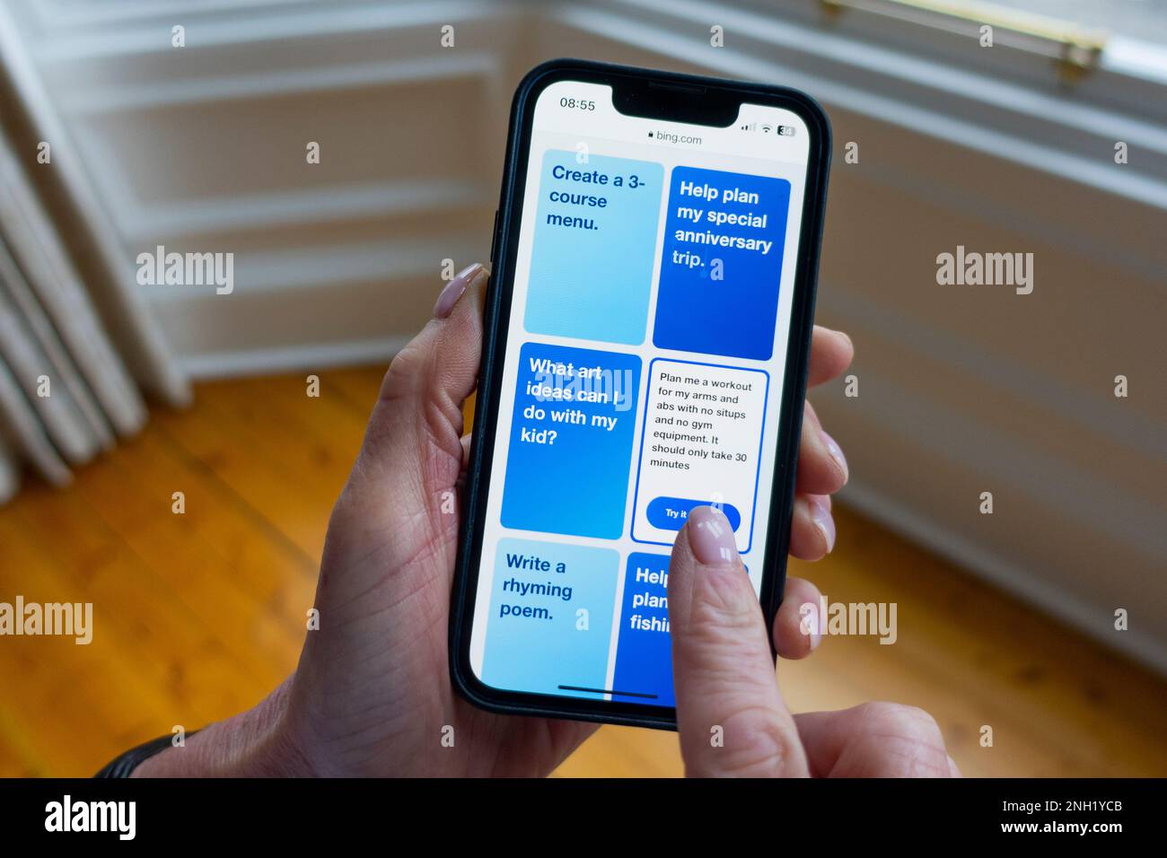 La persona tiene il telefono cellulare che mostra le nuove opzioni del motore di ricerca Microsoft ChatGPT OpenAI Bing Foto Stock