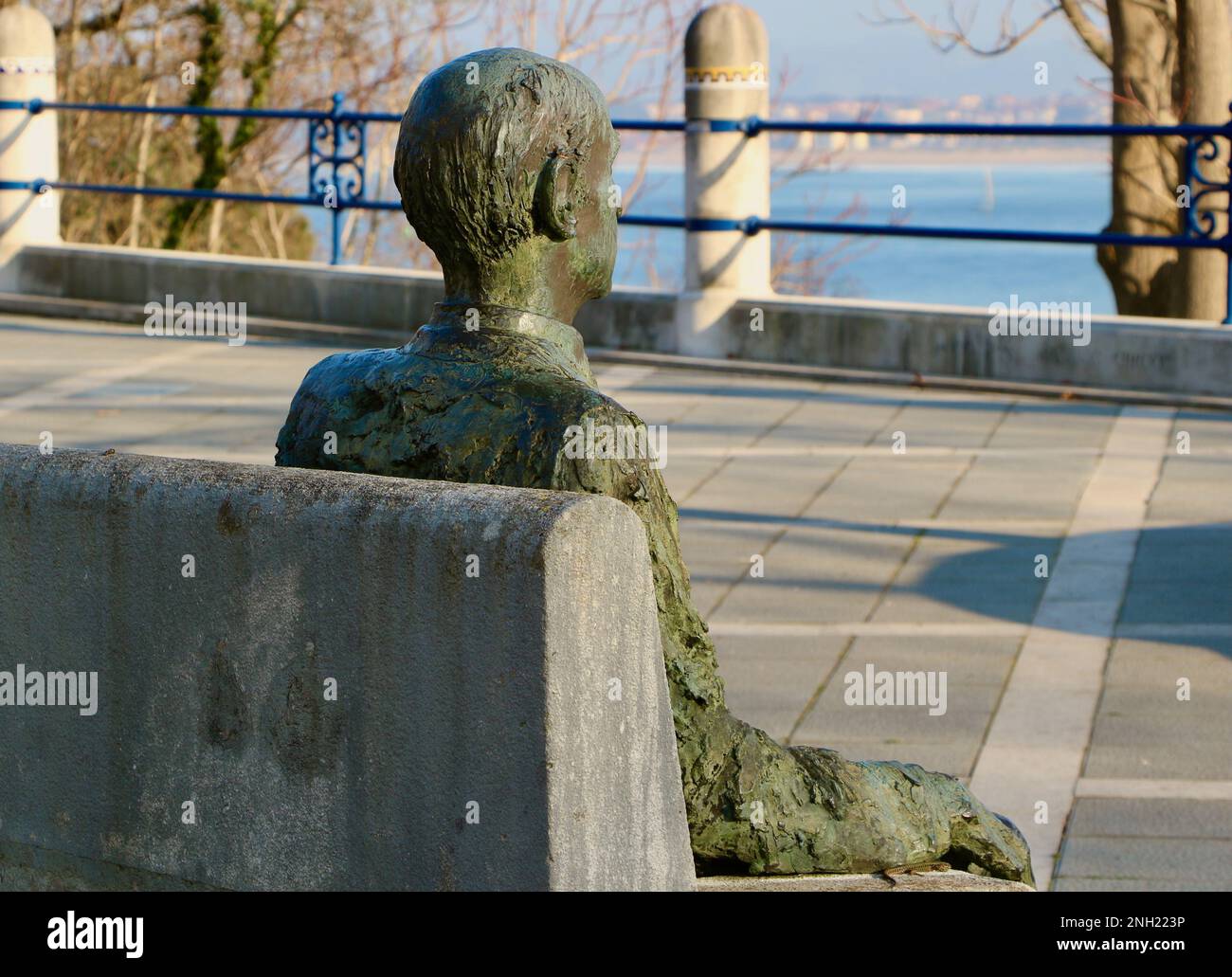 Statua in bronzo seduta del poeta Gerardo Diego Cendoya su una panca di cemento che guarda al mare Santander Cantabria Spagna Inverno sole Foto Stock