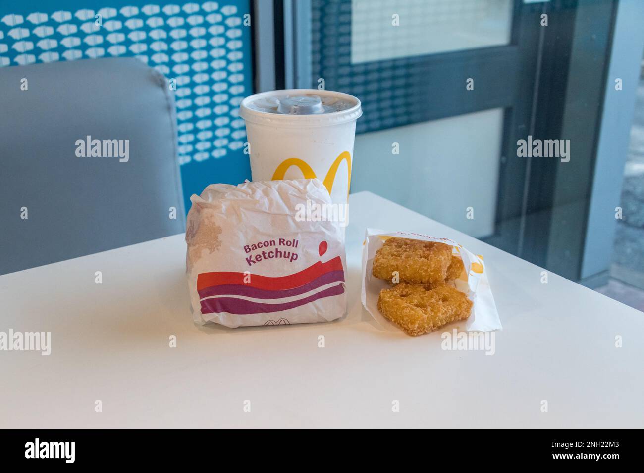 Stansted, Regno Unito - 3 dicembre 2022: Menu McDonalds con bacon Roll con Ketchup pomodoro, mini waffle di patate e Coca-Cola. Foto Stock