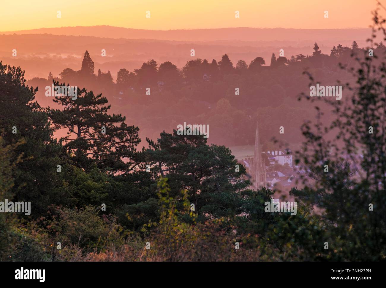 Vista elevata della città inglese di Dorking all'alba dalle colline del Surrey Foto Stock