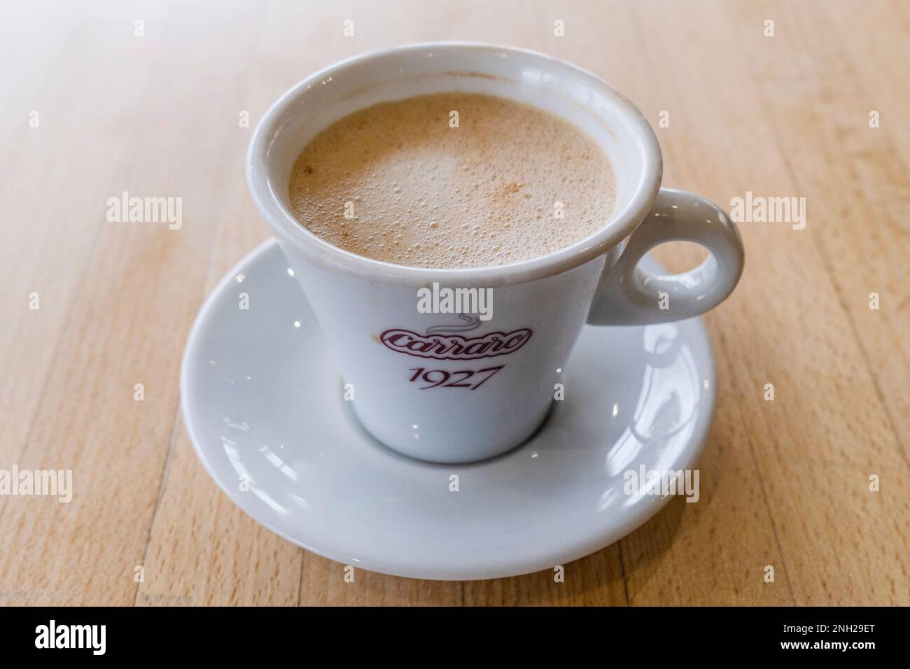 Un caffè bianco piatto su un tavolo in un ristorante. Foto Stock