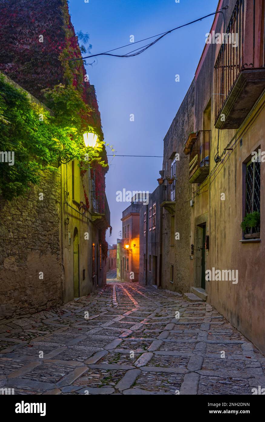Un caratteristico vicolo nel borgo medievale di Erice al calar della notte, in Sicilia Foto Stock