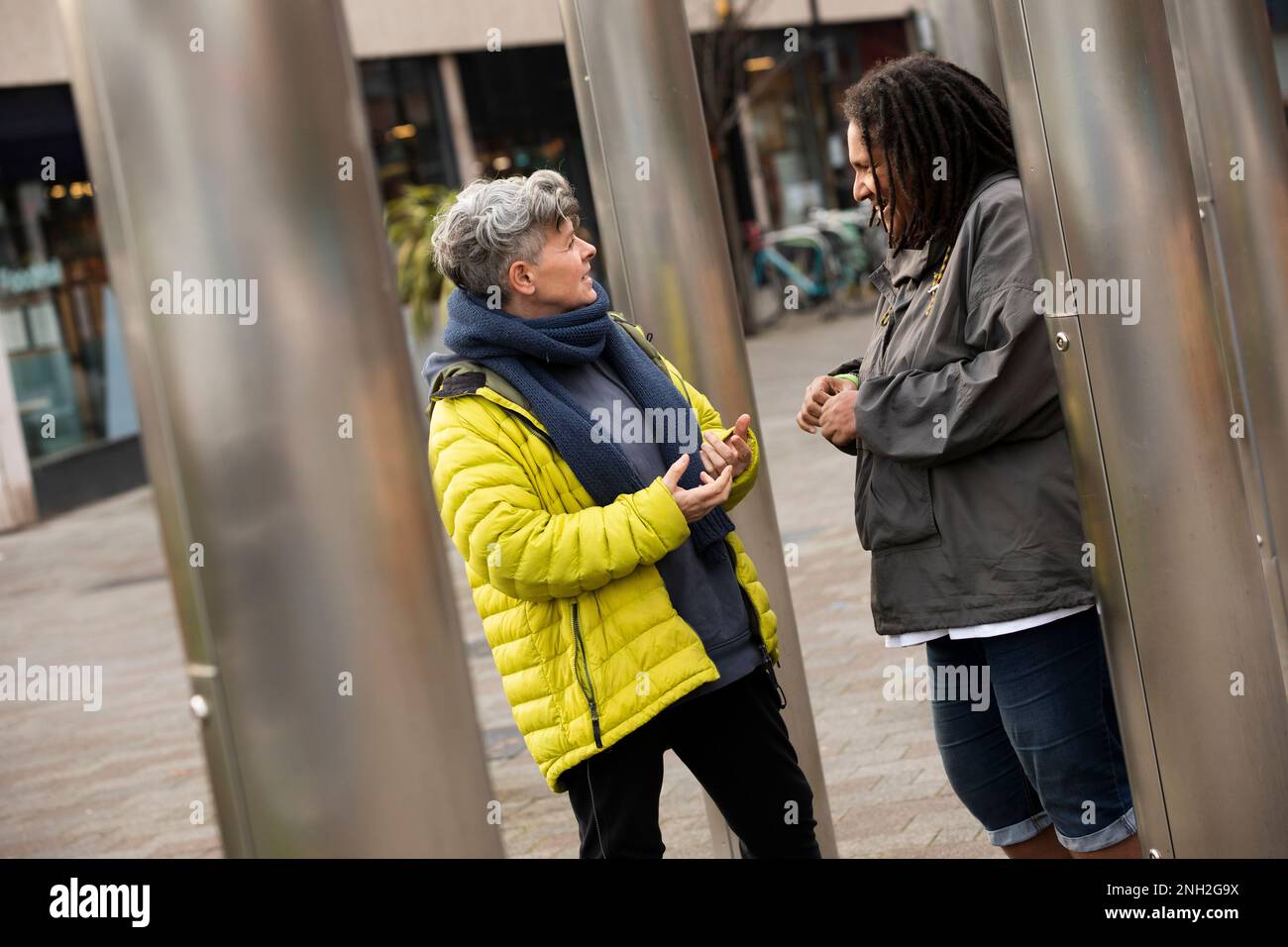 Due donne in piedi fuori, parlando. Manchester. Regno Unito. Foto Stock