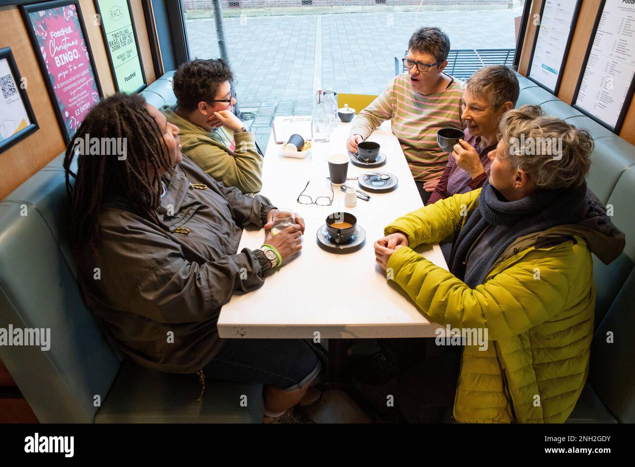 Gruppo di amici donne seduti a un tavolo e riunirsi per un caffè. Manchester. Regno Unito. Foto Stock