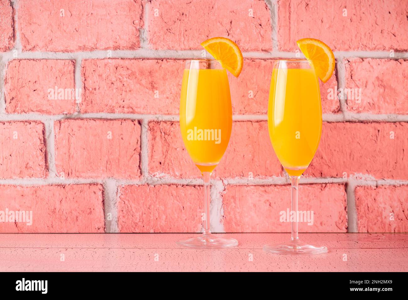 Rinfrescanti cocktail Mimosa all'arancia con champagne su sfondo luminoso. Foto Stock