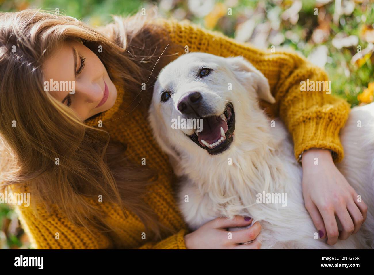 Belgrado, Serbia. Novembre 10th, 2022. Giovane bella donna che guarda il suo Golden Retriever e divertirsi in un parco in una giornata di sole. Foto Stock