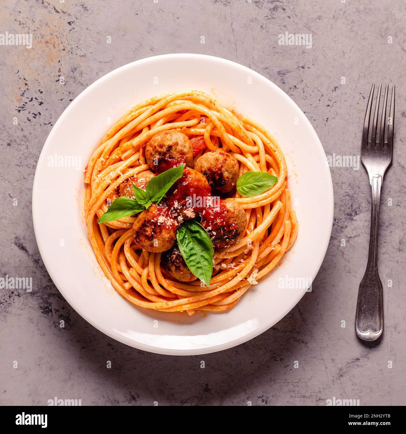 Spaghetti con polpette e salsa di pomodoro su sfondo di pietra, vista dall'alto Foto Stock