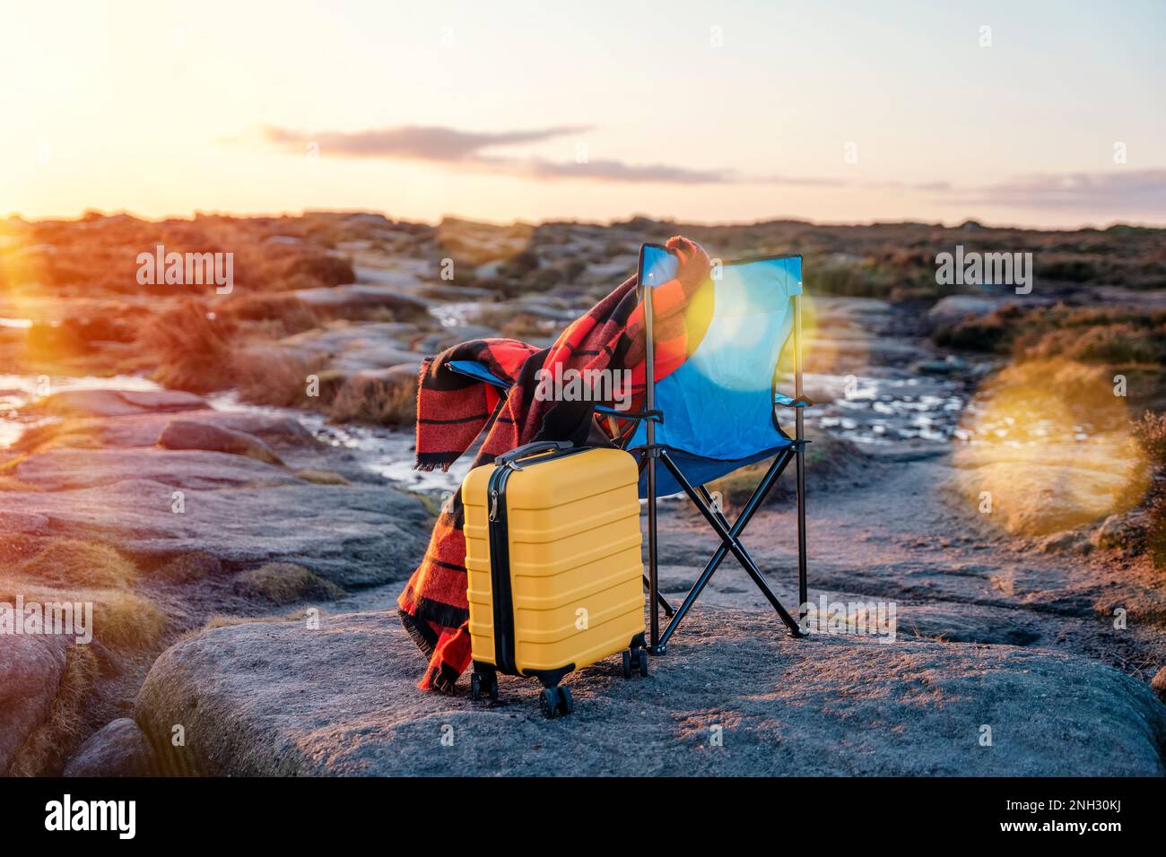 Sedia da spiaggia blu, custodia gialla, sciarpa arancione nel parco nazionale Peak District all'alba. Inverno freddo britannico. Concetto di turismo locale. Foto Stock