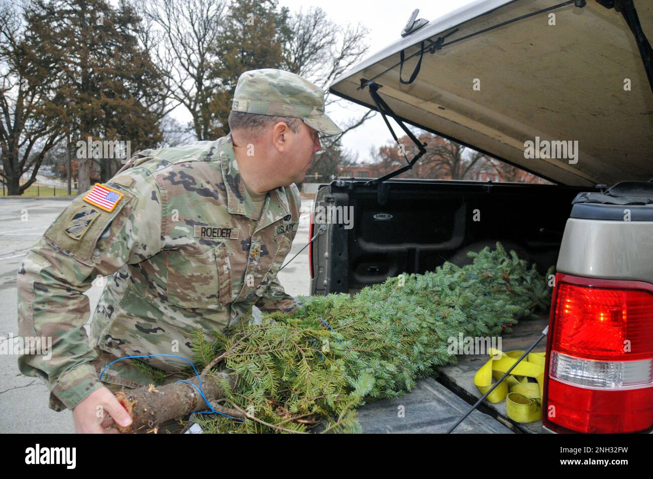 Thomas Roeder, assegnato al programma di addestramento del comando della missione, carica un albero di Natale nella parte posteriore del suo camion durante un evento alberi per le truppe a Fort Leavenworth. Alberi per le truppe dona 17.000 alberi ogni anno alle basi militari negli Stati Uniti e in tutto il mondo. Foto Stock