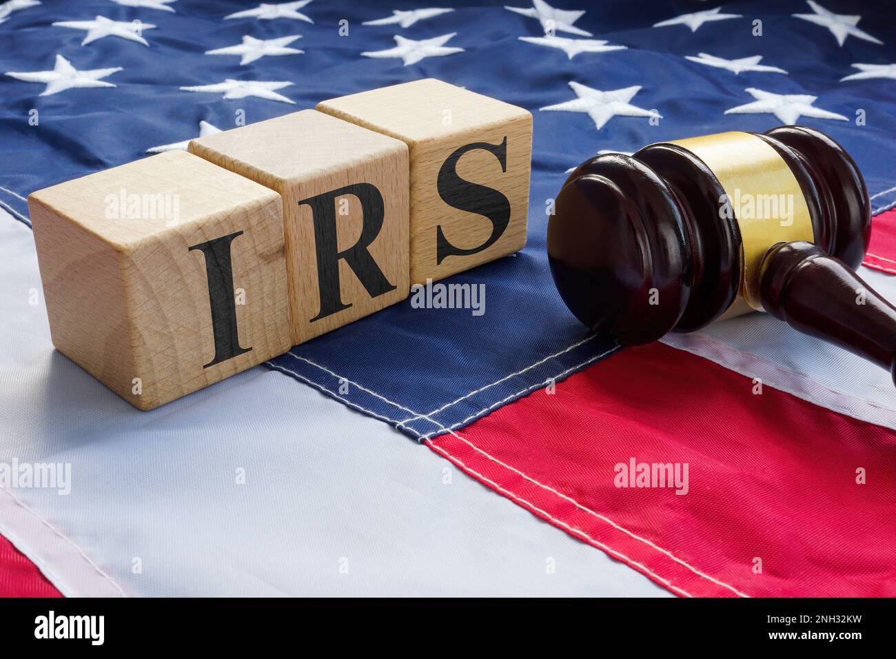 Bandiera USA, gavel e cubetti di legno con lettere IRS. Concetto di frode fiscale. Foto Stock