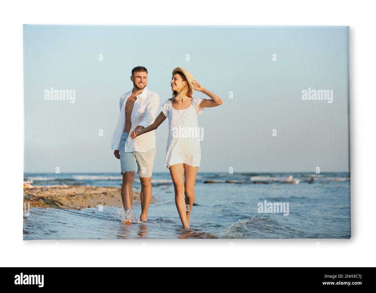 Foto stampata su tela, sfondo bianco. Felice giovane coppia sulla spiaggia Foto Stock