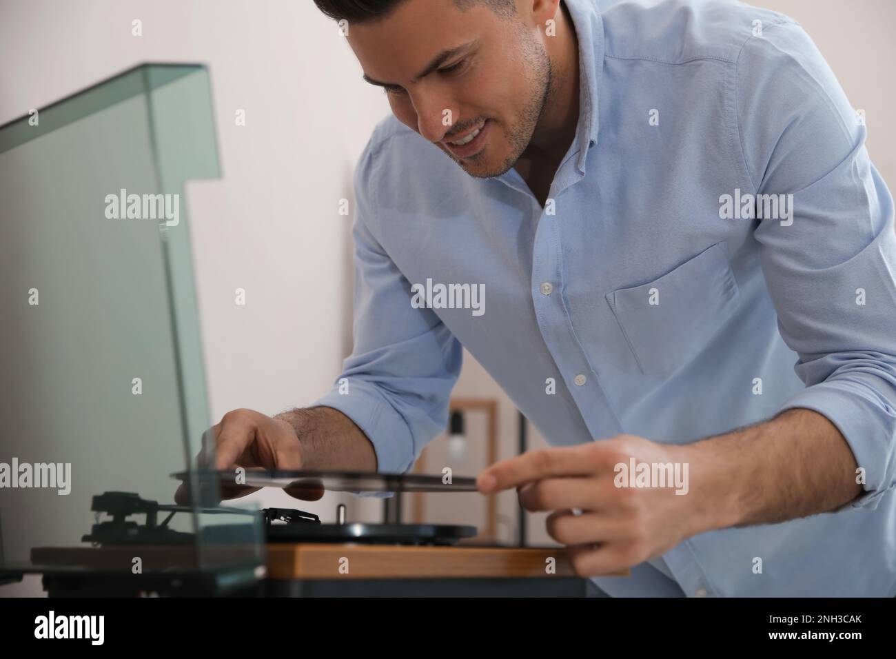 Un uomo felice che ascolta la musica con il giradischi a casa Foto Stock