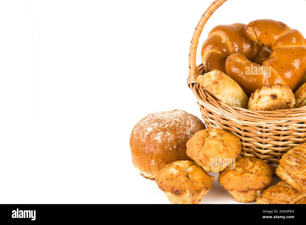 Croissant, muffin e altri dolci in un cestino di vimini isolato su sfondo bianco. Spazio libero per il testo. Foto Stock