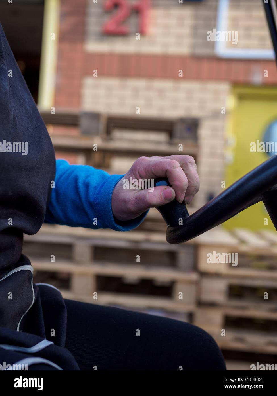 donna che guida un carrello elevatore a forche in primo piano sul volante Foto Stock