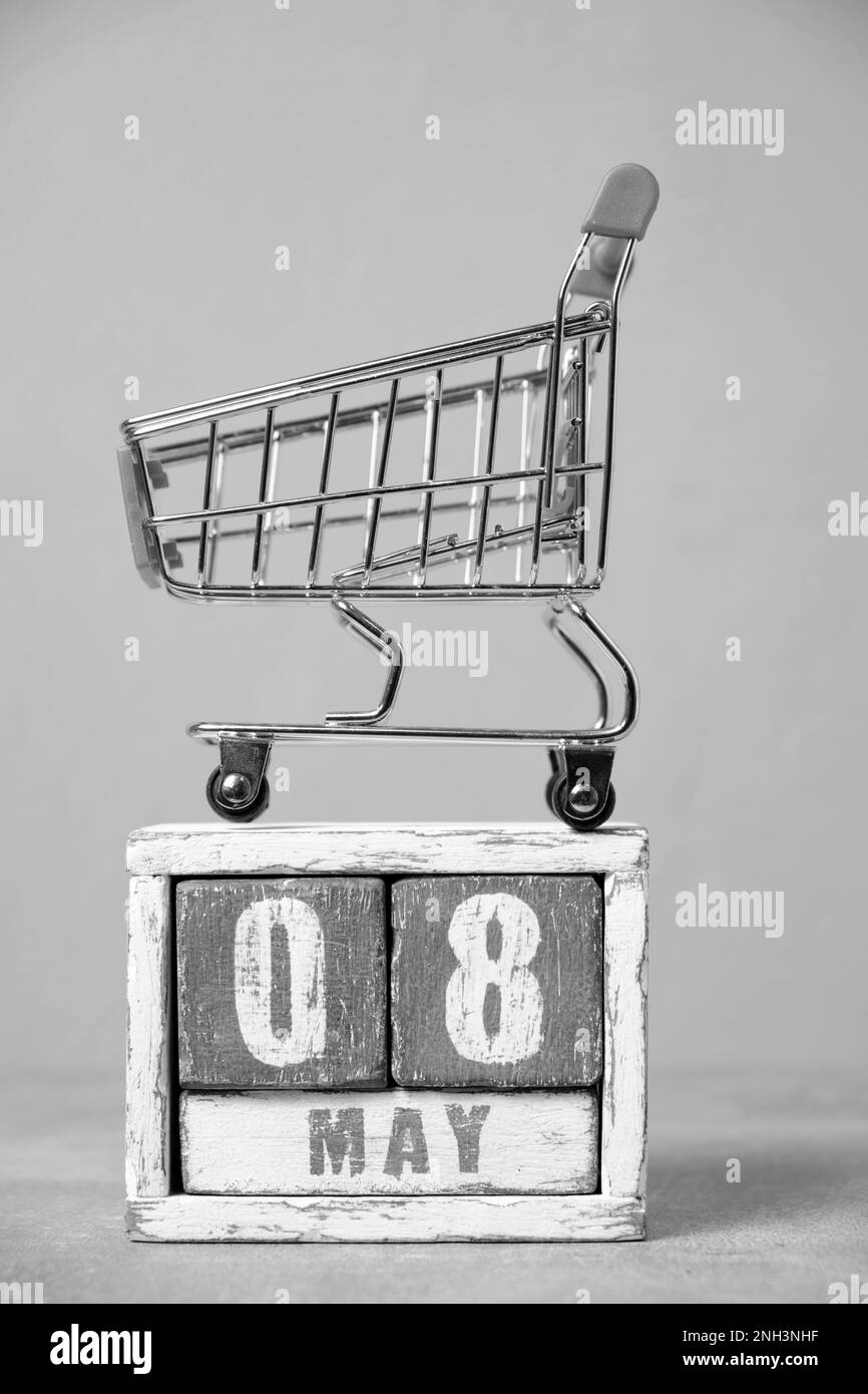 Maggio 08, carrello della spesa e calendario grigio di legno background.Concept per Fair Trade Day Foto Stock