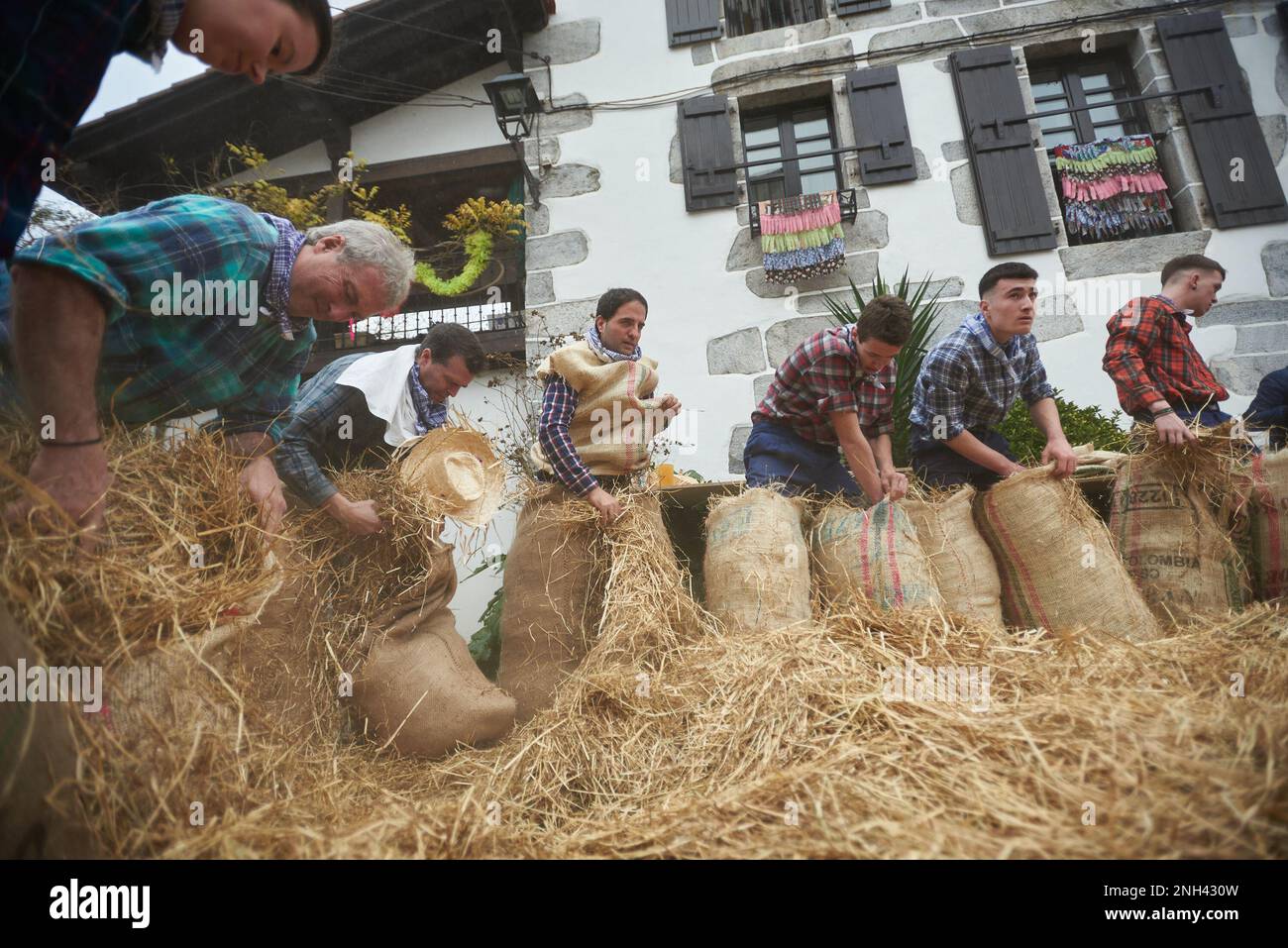 Lesaka, Spagna. 18th Feb, 2023. Diversi partecipanti al carnevale riempiono i loro costumi di paglia, ed è per questo che gli uomini con il vecchio sacco ripieno di paglia sono chiamati 'zaku-zaharrak', al carnevale di Lesaka. Gli 'zaku-zaharrak' sono caratteri tipici del carnevale di Lesaka, ripieni di sacchi pieni di paglia con le loro facce coperte da sciarpe, che portano i neri gonfiati per colpire le persone che camminano per le strade della città al tramonto. (Foto di Elsa A Bravo/SOPA Images/Sipa USA) Credit: Sipa USA/Alamy Live News Foto Stock