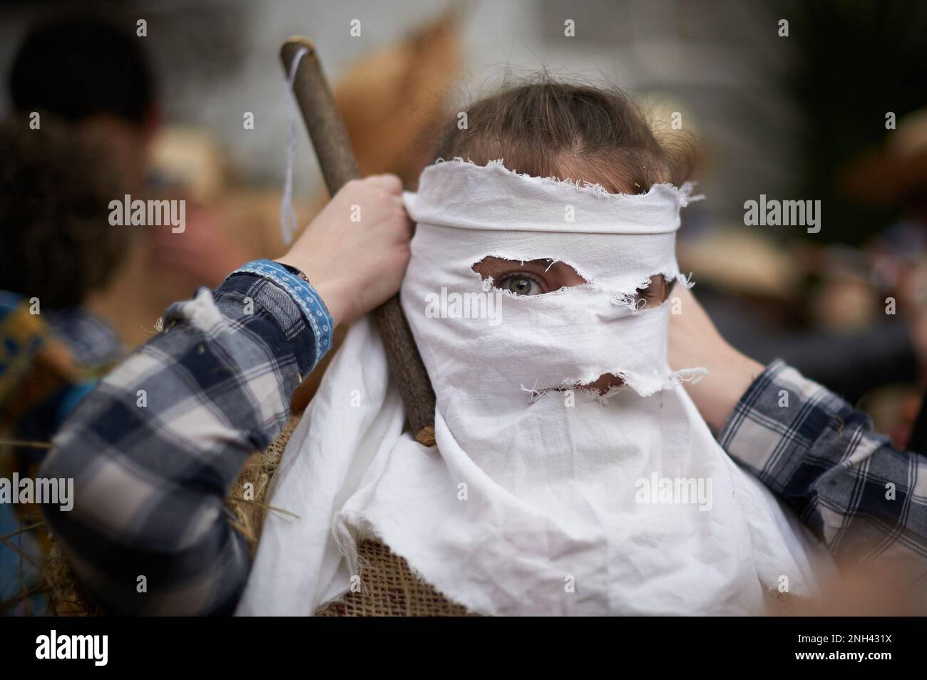 Lesaka, Spagna. 19th Feb, 2023. Una ragazza travestita come 'zaku-zahara' mette la sciarpa bianca che fa parte del costume durante il carnevale di Lesaka. Gli 'zaku-zaharrak' sono caratteri tipici del carnevale di Lesaka, ripieni di sacchi pieni di paglia con le loro facce coperte da sciarpe, che portano i neri gonfiati per colpire le persone che camminano per le strade della città al tramonto. (Foto di Elsa A Bravo/SOPA Images/Sipa USA) Credit: Sipa USA/Alamy Live News Foto Stock