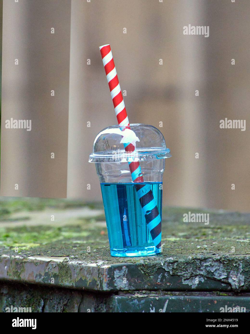 paglia a strisce rosse e bianche in una bevanda blu cielo Foto Stock