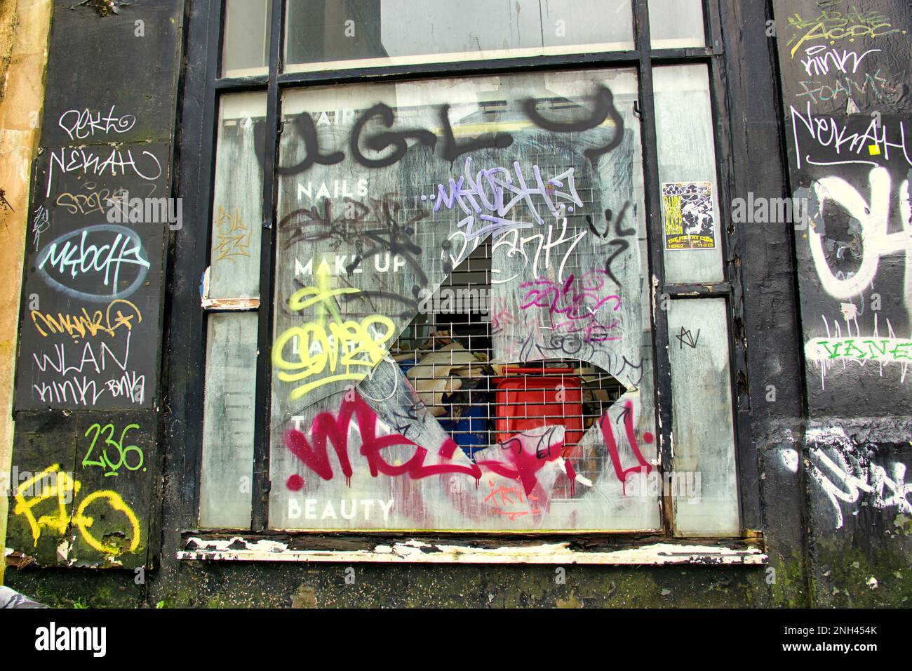 salone di bellezza vandalizzato e graffiti con finestra rotta Foto Stock