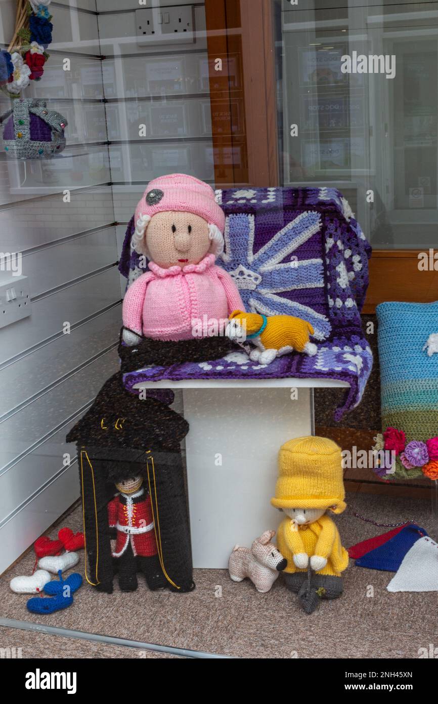 Le bambole a maglia sono esposte in una vetrina per celebrare la vita e il Platinum Jubilee della Regina Elisabetta II a St Ives, Cambridgeshire, Regno Unito Foto Stock