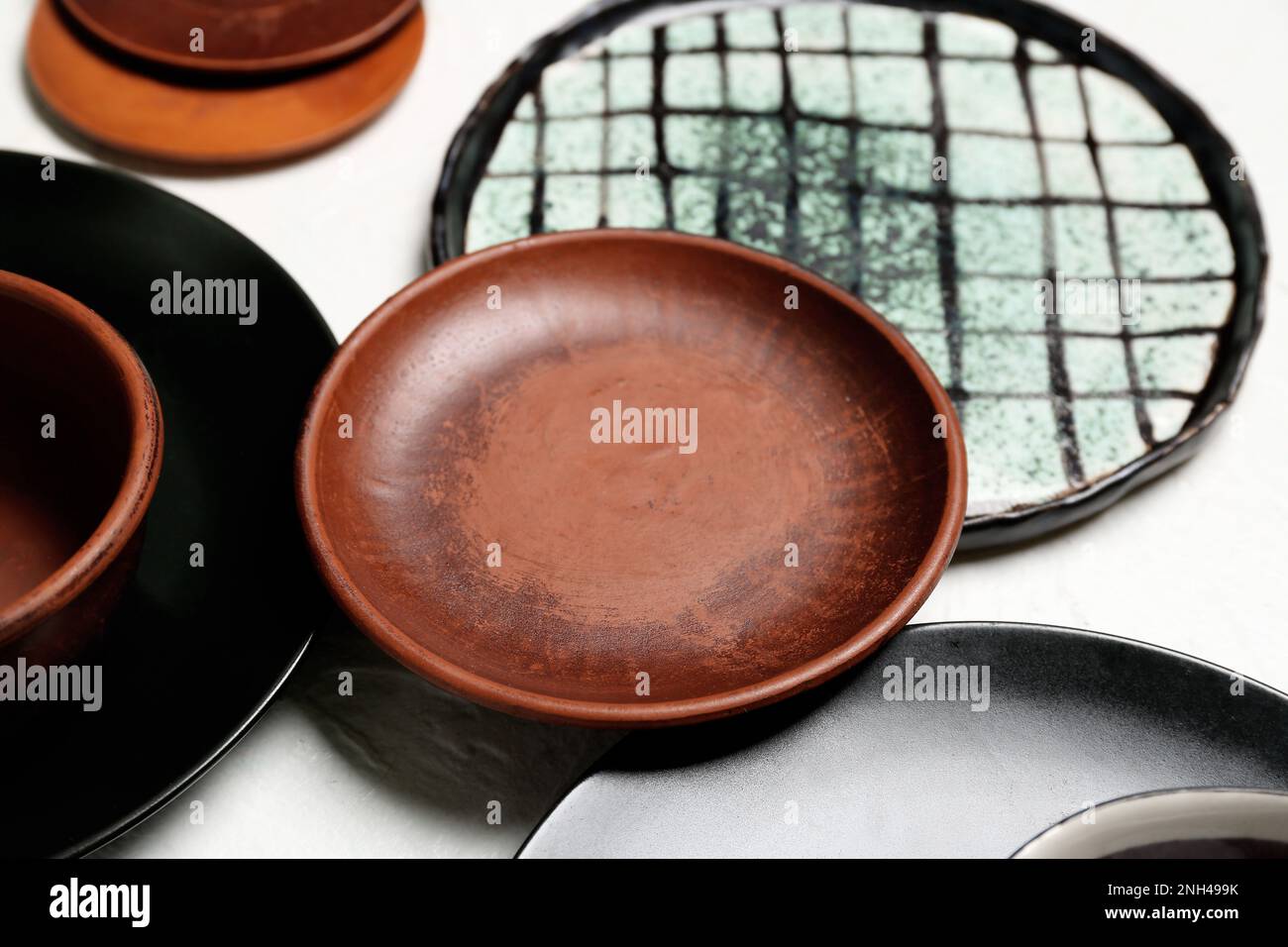 Pulire le piastre e le ciotole in ceramica su sfondo bianco Foto Stock