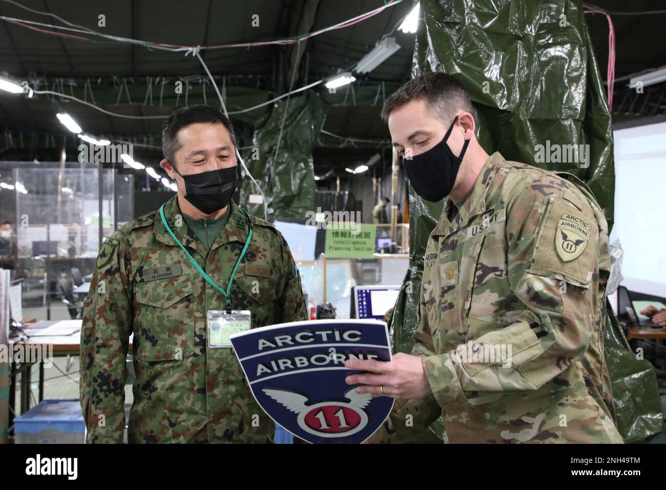 Il maggiore David Fasone della Brigata 1st, 11th divisione aerea, presenta una cresta unitaria ad un membro della forza di autodifesa di terra del Giappone, 12 dicembre 2022, Camp Higashi-Chitose, Giappone. Il cresta dell'unità è stato firmato e presentato come un segno di apprezzamento per gli sforzi di lavoro combinati durante l'esercizio. Foto Stock