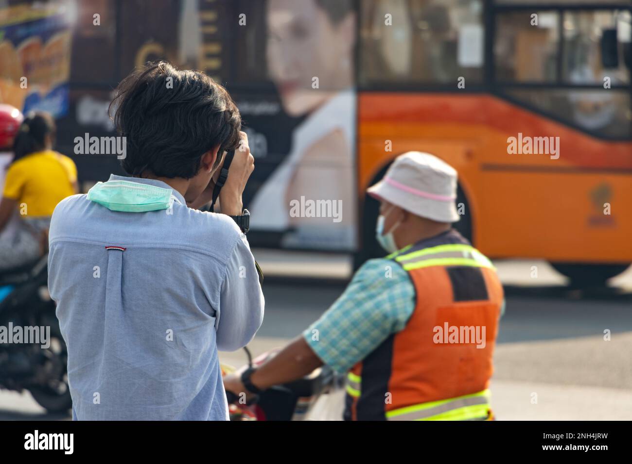 Un uomo con una macchina fotografica fotografa il traffico nel centro della città Foto Stock