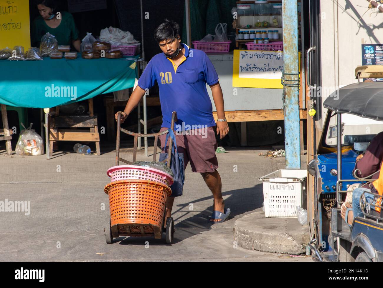 SAMUT PRAKAN, THAILANDIA, FEB 13 2023, Un portatore spingere un carrello con i cestini per il trasporto di un acquisto dal mercato Foto Stock