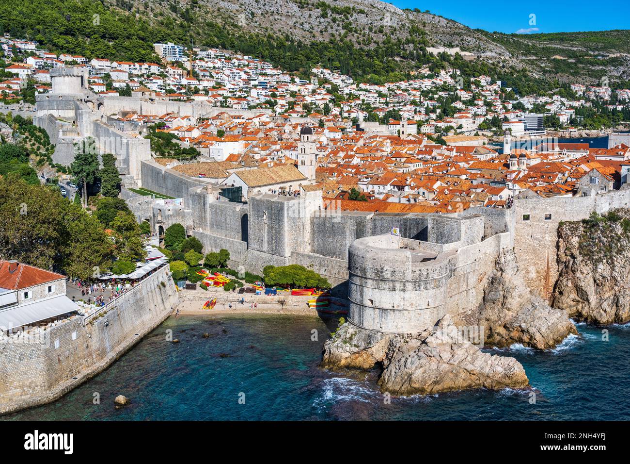 Spiaggia di sabbia alla Baia di Kolorina, con l'imponente Forte Bokar e i tetti di tegole rosse della città vecchia di Dubrovnik sulla costa dalmata della Croazia Foto Stock