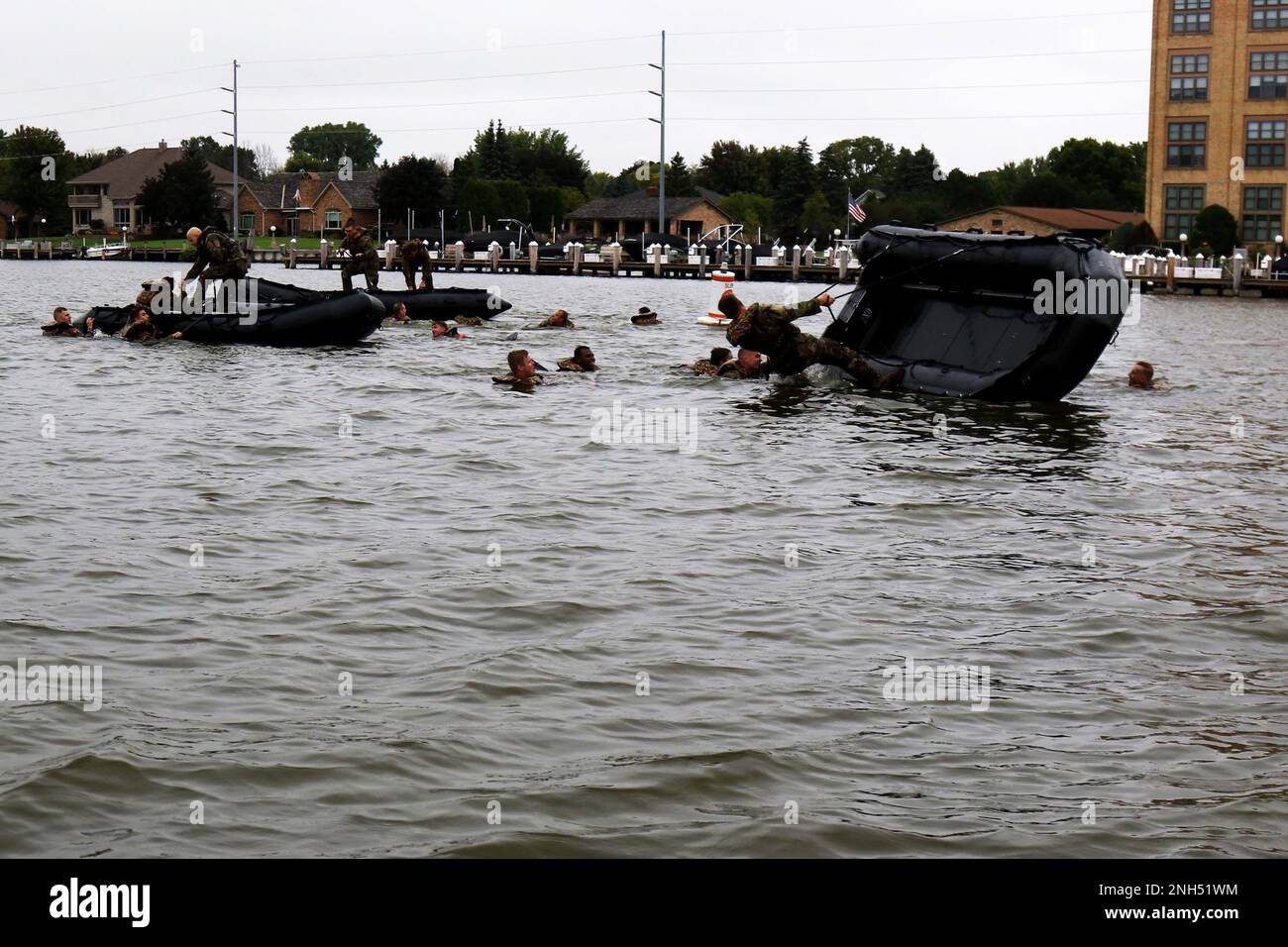 Wisconsin Army National Guard Soldiers della Compagnia A, 2-127 Reggimento della fanteria correre a capovolgere i loro mestieri di combattimento in gomma sul fiume Fox durante la corsa di combattimento Water Survival e Swift Water Rescue Training a Oshkosh, Wisconsin. Settembre 10. Una volta capovolta la zattera della squadra, i soldati hanno lavorato insieme per rovesciarla il più rapidamente possibile prima di tornare al punto di partenza. Brig. Il generale Matthew J. Strub, vicedirettore generale per l'esercito del Wisconsin, ha dichiarato che questo evento di formazione, reso possibile attraverso il supporto dei partner della comunità, sta per essere organizzato Foto Stock