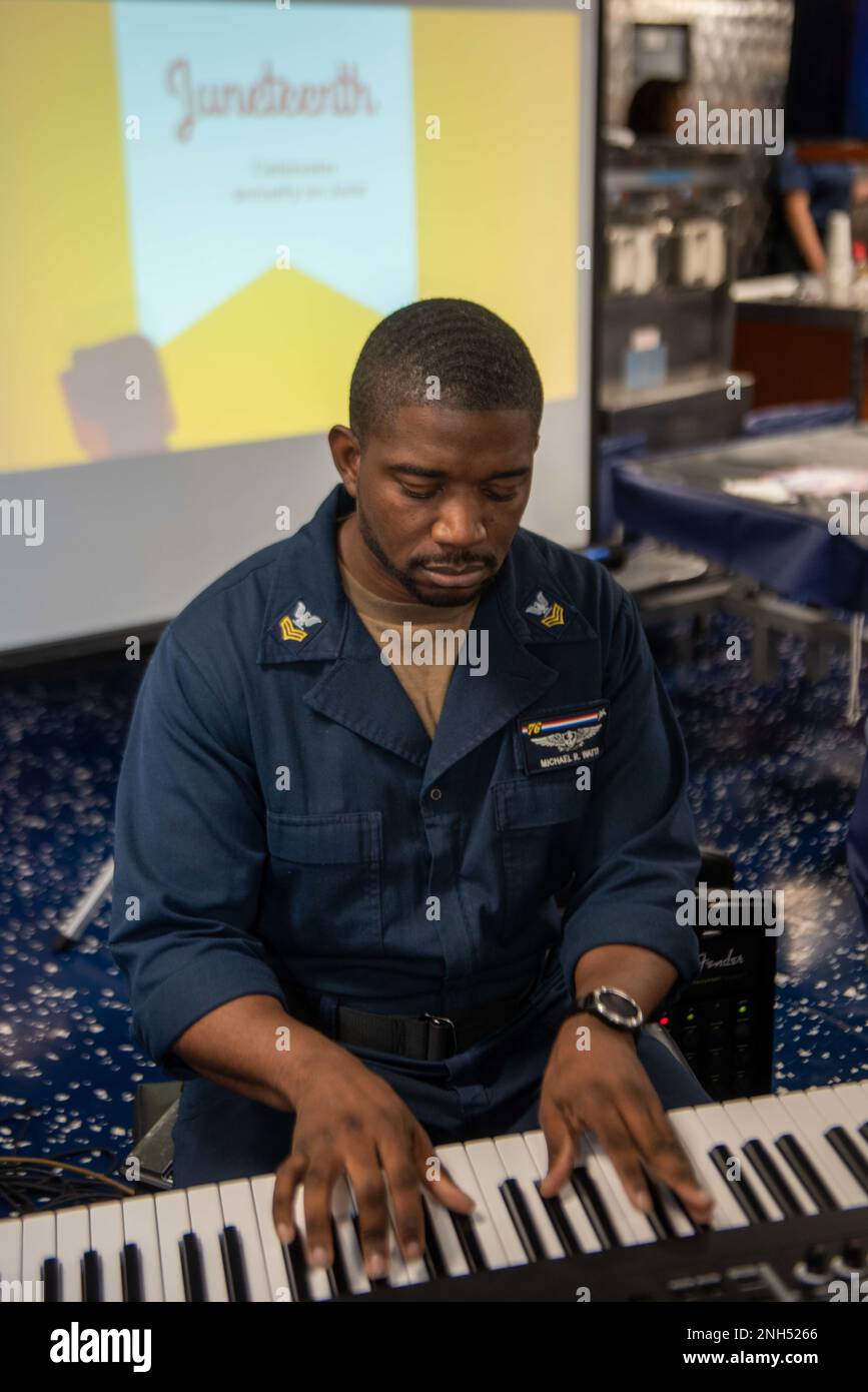 220620-N-UF592-1018 MARE DELLE FILIPPINE (20 giugno 2022) Aviation Electrician’s Mate 1st Class Michael Watts, di Coolidge, Georgia, suona il pianoforte durante una celebrazione del mese di giugno sul ponte di poppa degli Stati Uniti L’unica portaerei della Marina schierata a termine USS Ronald Reagan (CVN 76). La celebrazione del XVII giugno di Ronald Reagan ha incluso presentazioni sulla storia afro-americana e sulla musica dei membri dell’equipaggio. Ronald Reagan, il fiore all'occhiello del Carrier Strike Group 5, fornisce una forza pronta per il combattimento che protegge e difende gli Stati Uniti, e sostiene alleanze, partnership e collettività marittime Foto Stock