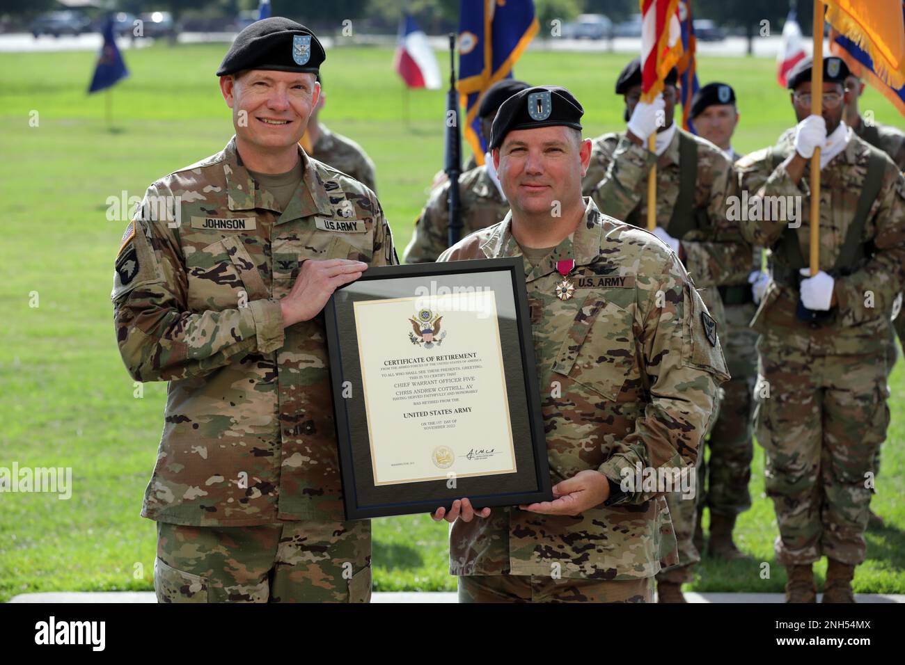 Il col. Michael Johnson, comandante della Brigata dell'Aviazione 110th, presenta il capo ufficiale del warrant 5 Chris Cottrill, ex capo ufficiale del warrant del comando, con un certificato di pensione durante la cerimonia di cambio di responsabilità della Brigata dell'Aviazione 110th a Howze Parade Field, Fort Rucker, Alabama, 21 giugno 2022. Foto Stock